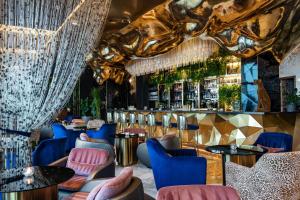 a restaurant with blue and pink chairs and a bar at Jumeirah Burj Al Arab Dubai in Dubai