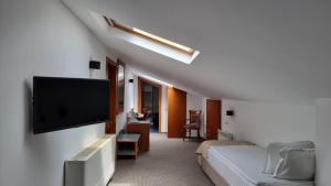 a hotel room with a bed and a flat screen tv at Hotel Duke Romana in Bucharest
