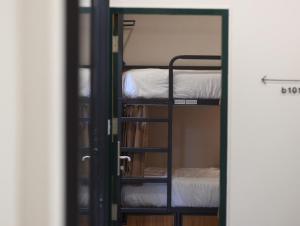 a door leading into a room with bunk beds at Peace Factory Hostel in Bangkok