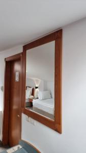 a mirror on a wall with a bed in a room at Hotel Duke Romana in Bucharest