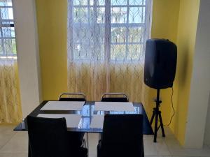 Zimmer mit einem Tisch mit Stühlen und einem TV in der Unterkunft mountain view apartment 2 in Roseau