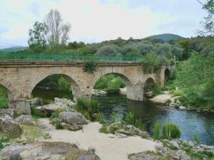 a stone bridge over a river with two bridges at Auberge U Mulinu in Casalabriva
