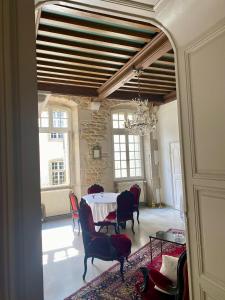 a dining room with a table and chairs and a chandelier at L'APPARTEMENT by Merveilles de Marie in Lons-le-Saunier