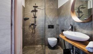 een badkamer met een toilet, een wastafel en een douche bij Hotel Pok Garni in Brezovica
