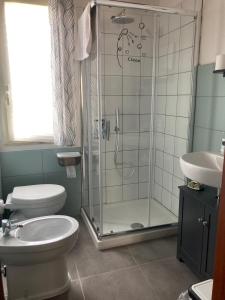 een badkamer met een douche, een toilet en een wastafel bij L’Ulivo in Formia