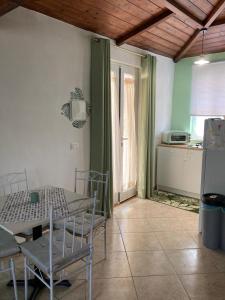 een kamer met een tafel en stoelen en een keuken bij L’Ulivo in Formia