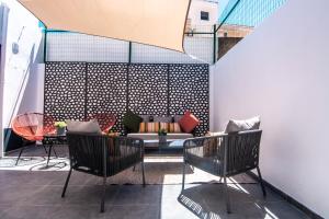 a patio with two chairs and a couch at Virginia Guest House in Lagoa
