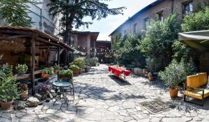 einen Innenhof mit einem roten Tisch und Topfpflanzen in der Unterkunft Tiflis Hotel in Tbilisi City