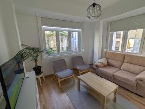 Apartamento Vila Morena في مالبيسا: غرفة معيشة مع أريكة وكرسيين