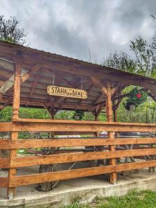 um gazebo de madeira com uma placa em Cabana „Stâna din Deal” em Proviţa de Sus