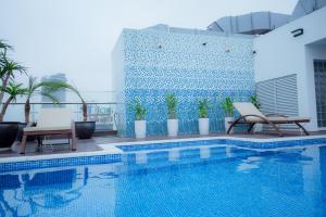 a swimming pool with two chairs next to a building at PH Hotel & Apartment in Hai Phong