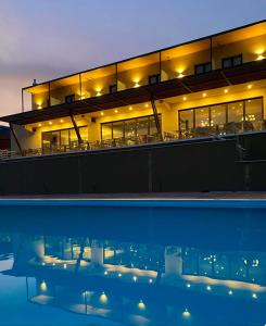 een gebouw met een zwembad in de nacht bij AKROTHEA suites & lounge in Tripolis