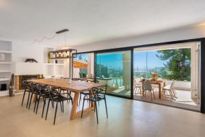 een eetkamer en een keuken met een grote houten tafel en stoelen bij Villa Romero Renovated in Sant Rafael