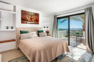 een slaapkamer met een bed en een groot raam bij Villa Romero Renovated in Sant Rafael