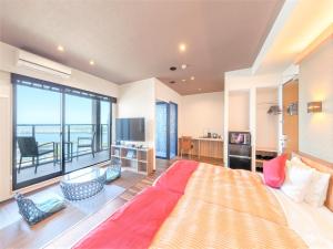 1 dormitorio grande con 1 cama grande y balcón en LiVEMAX RESORT Atami Sea Front en Atami