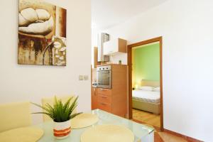 a living room with a table and a bedroom at Apartman Barkunada in Vodnjan