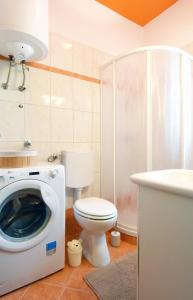 a bathroom with a toilet and a washing machine at Apartman Barkunada in Vodnjan +36 photos