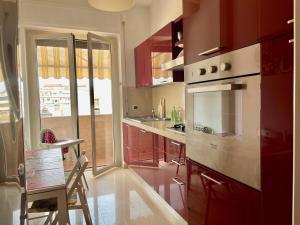 a kitchen with red cabinets and a stove top oven at Le Ortensie in centro e vicino al mare in Pescara