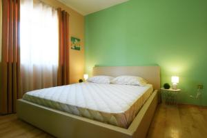 a bedroom with a bed with white sheets and a window at Apartman Barkunada in Vodnjan