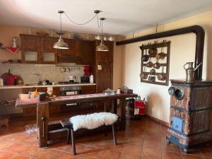 a kitchen with a wooden table and a stove at Appartamento “Sut l’Ala” in Netro
