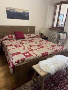 a bedroom with a bed with a red and white blanket at Appartamento “Sut l’Ala” in Netro