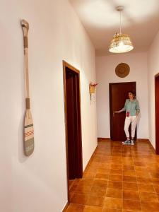 a woman standing in a room with a broom on the wall at B&b da Tizzy in San Domino