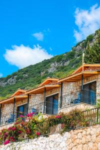 卡斯的住宿－Kaş Köy Hotel，一座带阳台的建筑,山上有鲜花