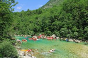 un gruppo di persone che fanno rafting lungo un fiume di Hostel X Point a Kobarid