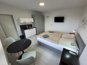 um pequeno quarto com uma cama, uma mesa e uma cozinha em Guesthouse WI rooms em Jülich