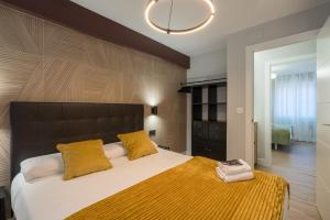 sypialnia z dużym łóżkiem z żółtymi poduszkami w obiekcie Villa Hita apartment by People Rentals w mieście Bilbao