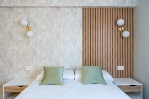 sypialnia z łóżkiem z białą pościelą i zielonymi poduszkami w obiekcie Villa Hita apartment by People Rentals w mieście Bilbao