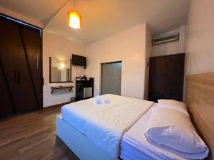 een slaapkamer met een groot bed met witte lakens en kussens bij The Green Season Resort in Ban Mae Kham Lang Wat
