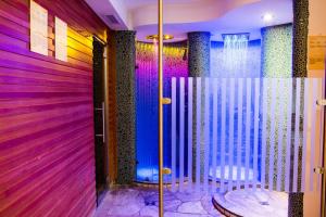 a room with purple walls and a shower with chairs at Apartments Aghel ***S in Selva di Val Gardena