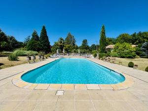 a pool in a yard with chairs and trees at Le logis de Lasteyrie in La Rochebeaucourt-et-Argentine