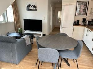 a living room with a couch and a table and chairs at Marken Apartments in Bergen