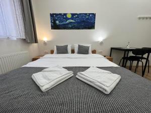 Vurk INN Paracin في باراسين: غرفة نوم عليها سرير وفوط