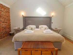 a bedroom with a large bed with two tables at The Piggery in Ledbury