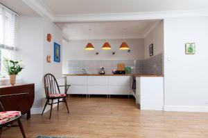 cocina con armarios blancos, mesa y sillas en East Linton flat, sleeps 2, en East Linton