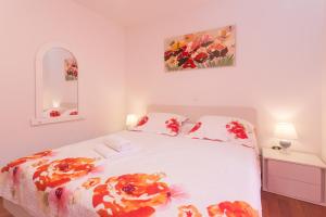 ein Schlafzimmer mit einem weißen Bett mit Blumen darauf in der Unterkunft Villa Tomic in Trnbusi