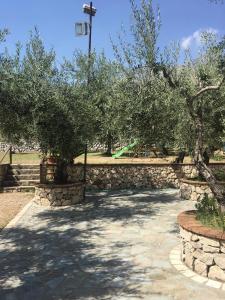 een loopbrug met bomen en een stenen muur bij L’Ulivo in Formia