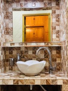 a sink in a bathroom with a mirror at Guest House Kartuli Suli in Telavi