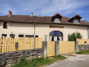 a house with a wooden fence and a house at Les cabanes de pellier in Charcier