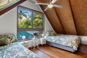 a bedroom with two beds and a window at Buddha's Bungalow in Byron Bay