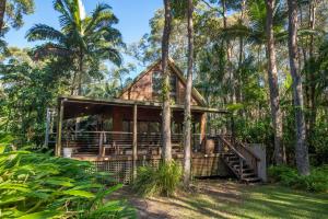 a house in the woods with palm trees at Buddha's Bungalow in Byron Bay