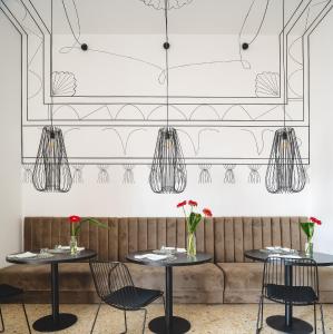 a restaurant with two tables and chairs and a couch at Ortigia's gate in Siracusa