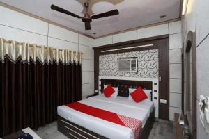 1 dormitorio con 1 cama grande con almohadas rojas en OYO Hotel Vanshika en Agra