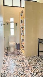 a bathroom with a toilet and a tile floor at Bannamhoo Bungalows in Pai