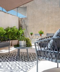 a patio with chairs and a table and potted plants at Ortigia's gate in Siracusa