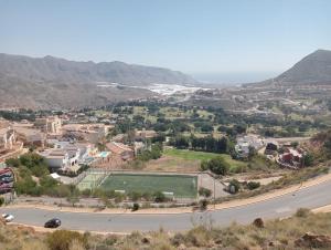 uma vista para uma cidade com um campo de ténis numa estrada em Apartamento Residencial Colinas del Golf, Envía, Almería em La Envia