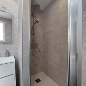 y baño con ducha y puerta de cristal. en Ático Ángela, en Valladolid